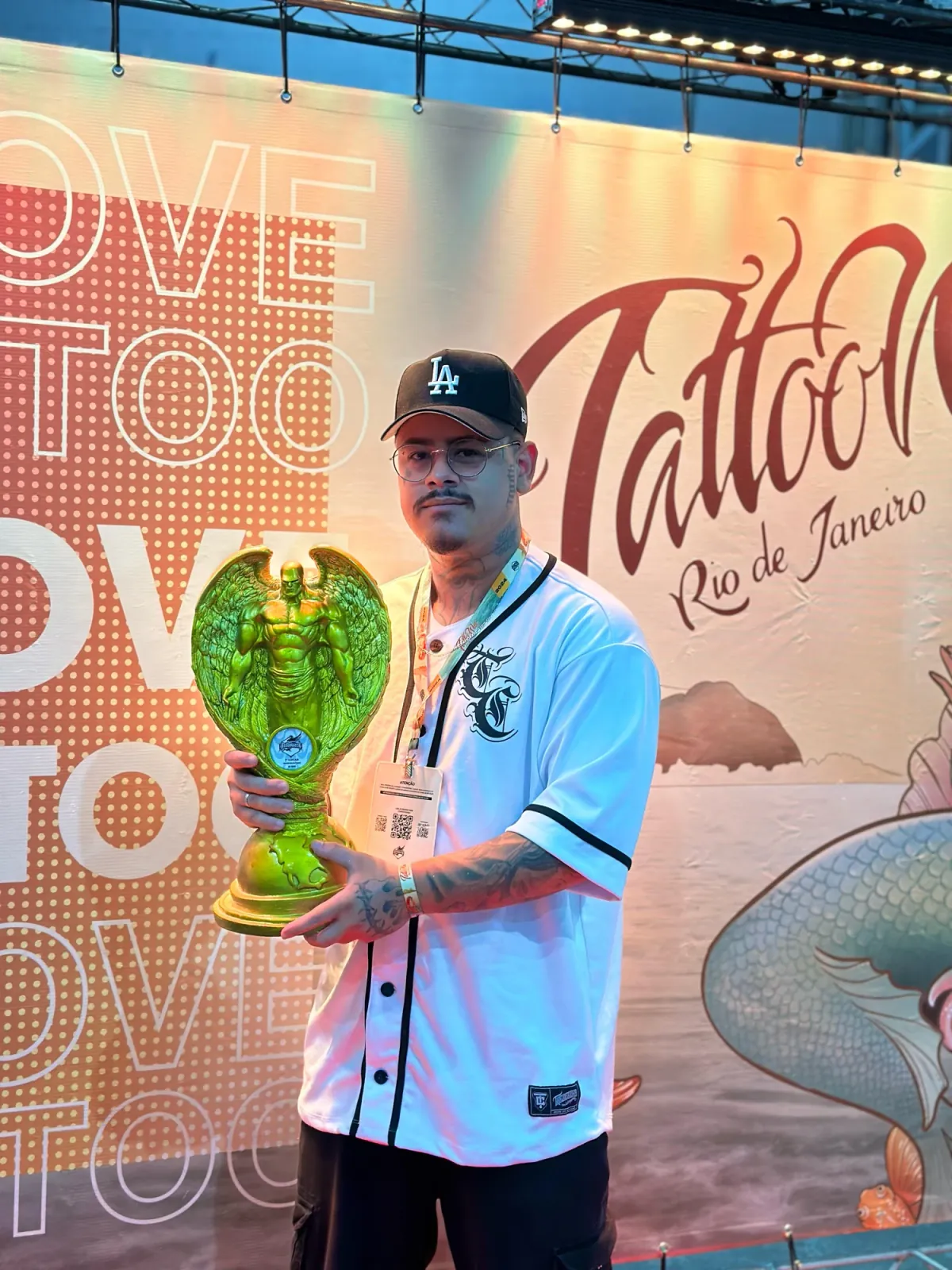 Icaro segurando o troféu de 1º lugar em Whip Shading na Tattoo Week Rio 2024